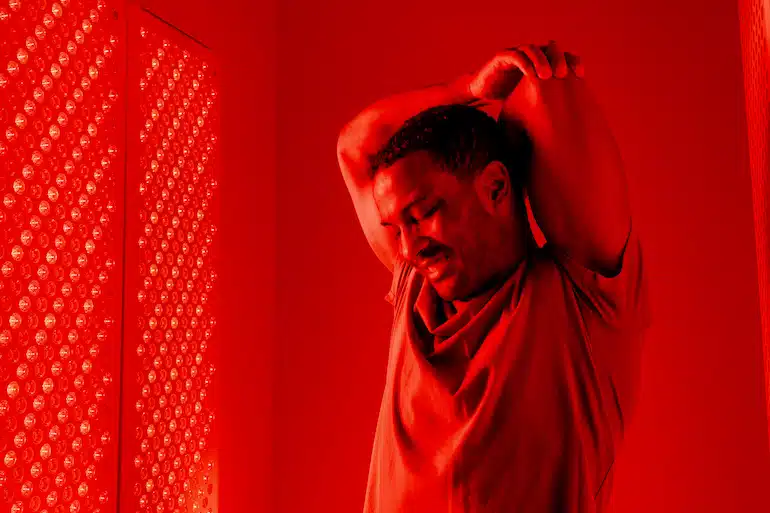 A man stretching under red light