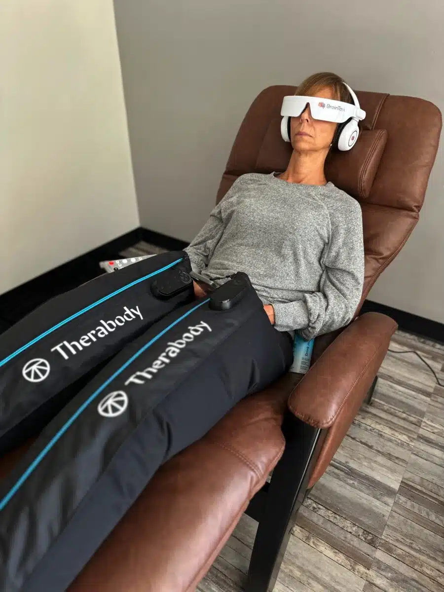 Woman laying down using Compression therapy on he rlegs.