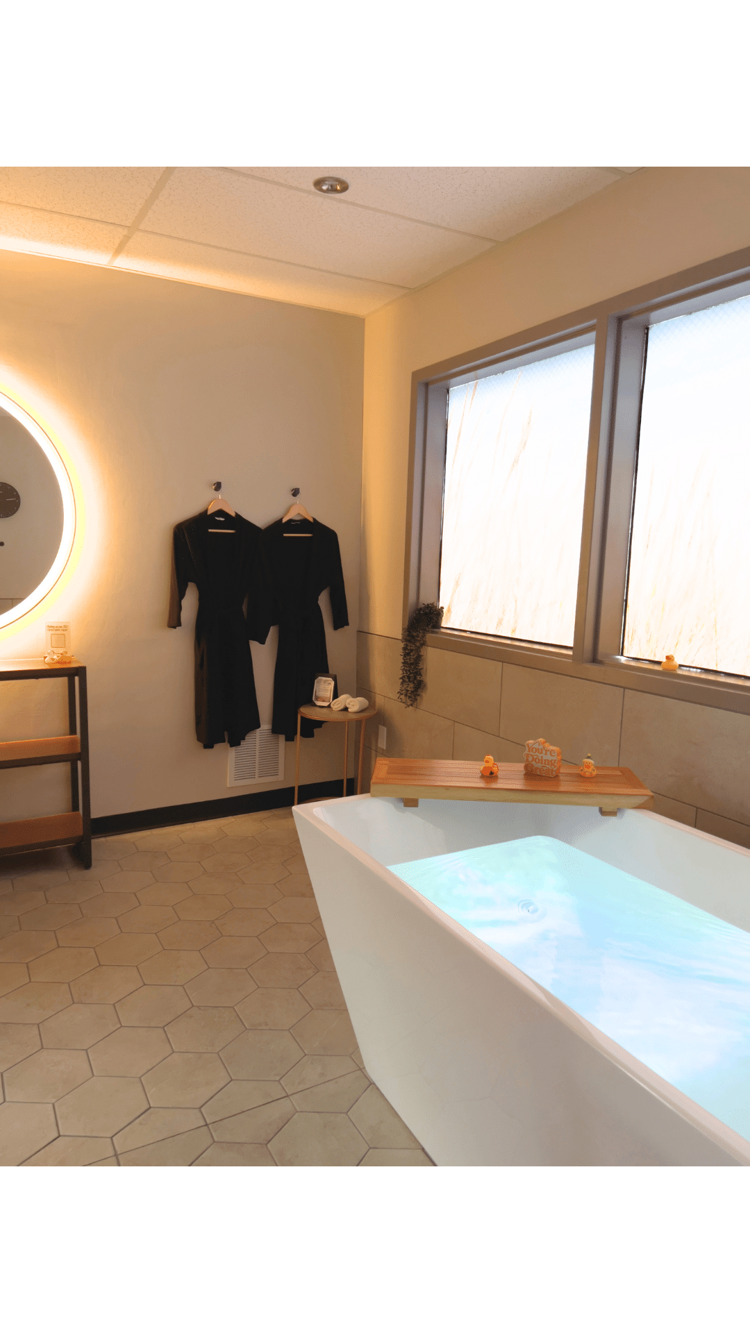 Cold Plunge tub with two robes hung in the background