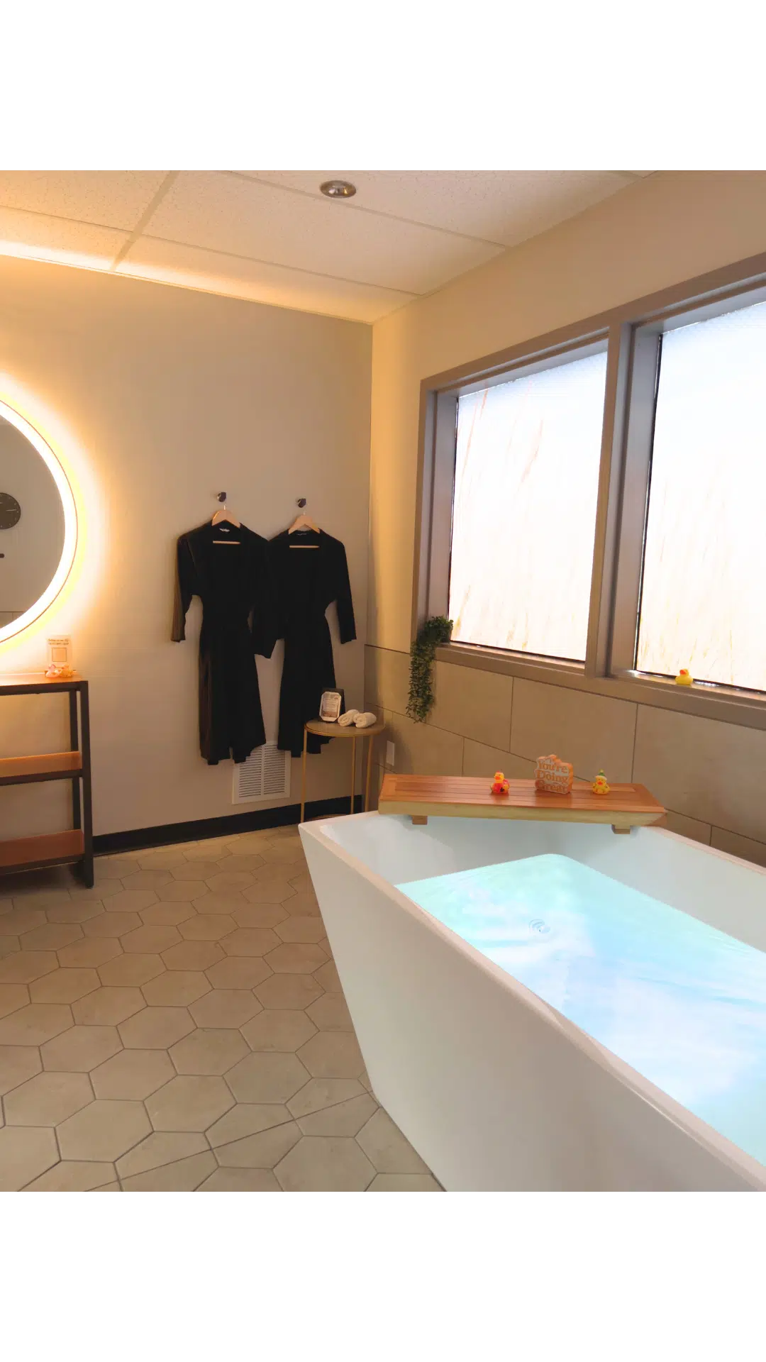 Cold Plunge tub with two robes hung in the background