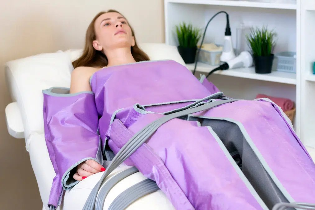 Woman receiving lymphatic drainage compression from suit